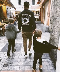 a man and two children are walking down the street