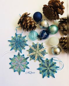 christmas ornaments and pine cones on a white surface