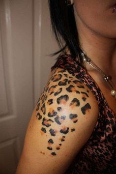 a woman's arm with leopard print on it and her hair in pony tail