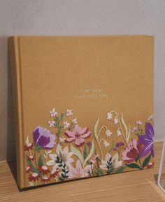 a book with flowers on it sitting on a table