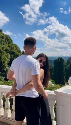 a man standing next to a woman on top of a balcony