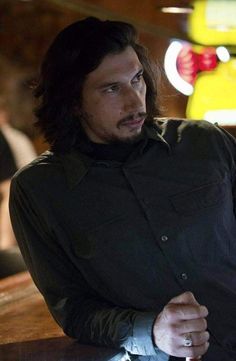 a man with long hair sitting at a table