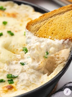 a piece of bread is being lifted from a skillet filled with mashed potatoes