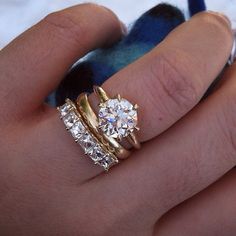 someone is holding their wedding ring in their hand and it looks like they have two diamonds on