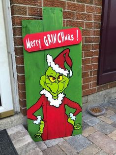 the grinch is painted on a wooden sign