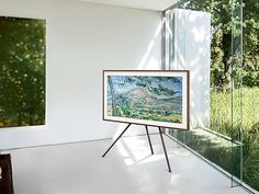 two paintings are on display in a room with white walls and flooring, along with a glass wall