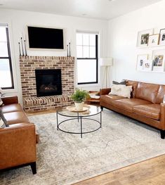 a living room with two couches and a television mounted above the fireplace in it