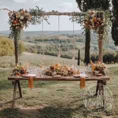 an outdoor table set up with flowers and greenery for a wedding reception in the countryside