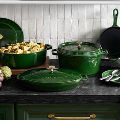 green pots and pans are sitting on the counter