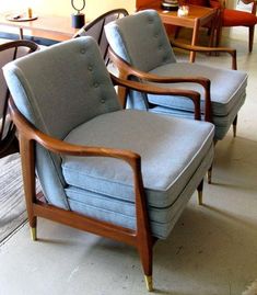 three blue chairs sitting next to each other in a room with wooden tables and lamps