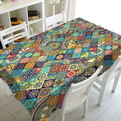 a dining room table covered with a multicolored quilt