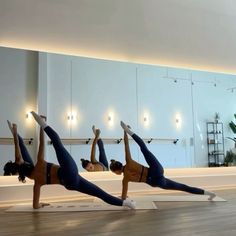 three women doing yoga poses in front of mirrors