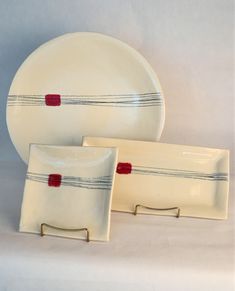 two white plates with red and black lines on them sitting next to each other in front of a white background