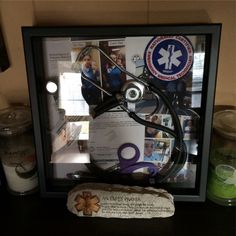 a framed medical display with scissors and other medical related items in the shadow box behind it