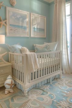 a baby's room decorated in blue and white with seashells on the wall