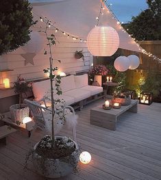 an outdoor patio decorated with lights and furniture