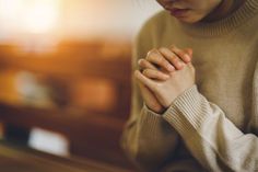 a woman with her hands folded in prayer