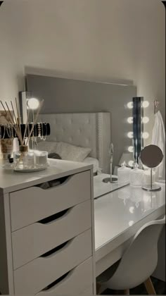 a white desk with lots of drawers and lights on it's headboard in a bedroom