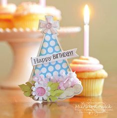 a birthday card with cupcakes and candles in the background