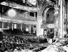 the interior of an old theater with lots of chairs and debris on the ground in front of it