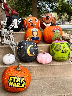 pumpkins painted to look like star wars characters are on the steps in front of a house