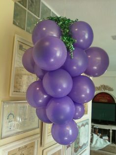 a bunch of purple balloons hanging from the ceiling