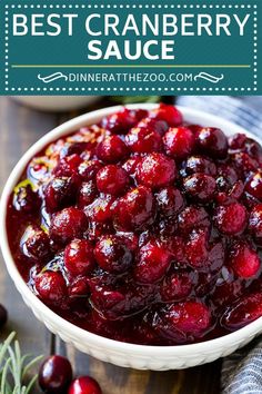 cranberry sauce in a white bowl on top of a wooden table with fresh cherries