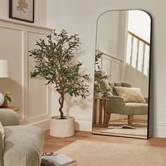 a mirror sitting on top of a wooden floor in a living room next to a couch