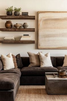 a living room filled with lots of furniture next to a painting on the wall and bookshelves