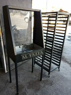 an old machine that is sitting on the ground in front of some metal racking