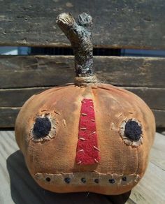 a small pumpkin with holes in it sitting on top of a wooden table