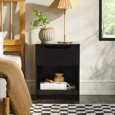 a bed room with a neatly made bed and a lamp on top of the night stand