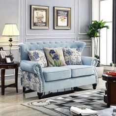 a living room with blue couches and pictures on the wall