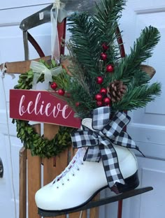 a pair of ice skates sitting on top of a sled next to a christmas wreath