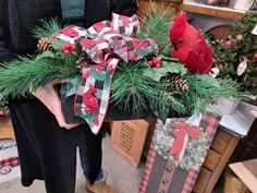 a person holding a christmas arrangement in their hands