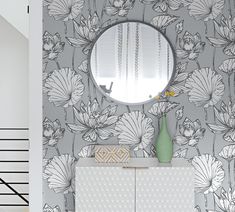 a bathroom with wall paper and mirror on the wall next to a cabinet that has a vase in front of it