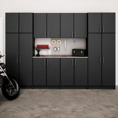 a motorcycle is parked in the middle of a garage with cabinets and appliances on the wall