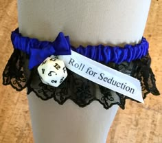 a white dice sitting on top of a black and blue garter