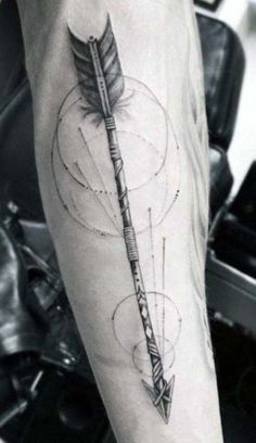 a person with a tattoo on their arm holding a pen and an arrow in the middle