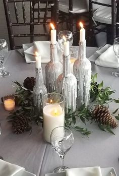 the table is set with candles, plates and napkins