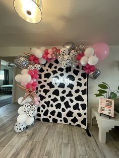 an animal print backdrop with balloons and decorations