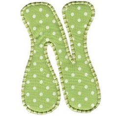 the letter w is made up of green and white polka dot fabric with small white dots on it