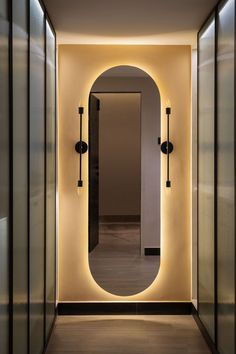 an empty hallway is lit up with lights and mirrors on either side of the door