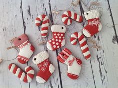 some red and white christmas decorations on a wooden table with string attached to the strings