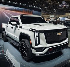 a white truck is on display at an auto show