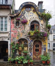 an old house with flowers and plants growing out of it