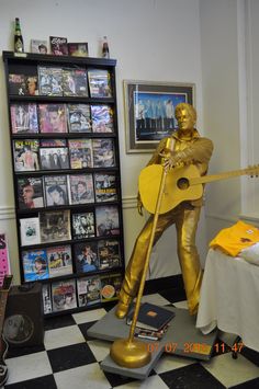 a gold statue holding a guitar in a room