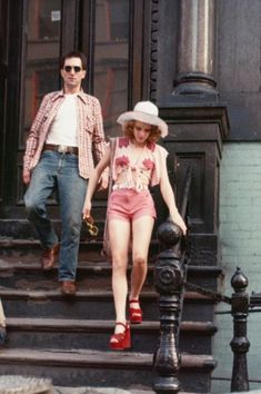 a man and woman walking down some steps