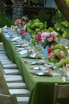 a long table is set with flowers and plates