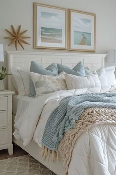 a bedroom with white bedding and two pictures on the wall